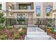 Close-up of a modern townhome entrance with stone accents, a black metal fence, and landscaped garden at 50 64Th S St, St Petersburg, FL 33707