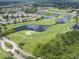 Wonderful aerial view featuring a lush golf course, tranquil lakes, surrounding homes, and scenic fairways at 511 Foxglove Cir # B, Sun City Center, FL 33573