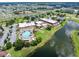 Community aerial featuring a pool, parking, surrounding green spaces, and a tranquil lake in a picturesque setting at 511 Foxglove Cir # B, Sun City Center, FL 33573