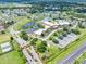 Extensive aerial view showcasing community buildings, parking areas, lush landscaping, nearby roadways, and serene lakes at 511 Foxglove Cir # B, Sun City Center, FL 33573