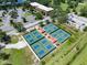 Aerial view of the tennis courts, parking area, and surrounding green spaces within the community at 511 Foxglove Cir # B, Sun City Center, FL 33573