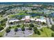 Great aerial view of the clubhouse, pool, parking, and other community amenities, alongside lush landscaping at 511 Foxglove Cir # B, Sun City Center, FL 33573