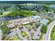 Aerial view of community clubhouse with pool, tennis courts, parking lot, and surrounding golf courses at 511 Foxglove Cir # B, Sun City Center, FL 33573