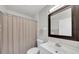 Clean bathroom with a large mirror, modern toilet, and a shower with a beige curtain at 511 Foxglove Cir # B, Sun City Center, FL 33573
