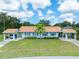 Charming single Gathering home featuring a well-manicured lawn, mature trees, and a light blue exterior at 511 Foxglove Cir # B, Sun City Center, FL 33573
