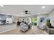Open-concept living room with modern furnishings, wood floors, and access to the dining area and outdoor patio at 511 Foxglove Cir # B, Sun City Center, FL 33573