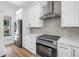 Kitchen features stainless appliances, bright cabinets, a stone backsplash, and stone countertops at 5124 3Rd N Ave, St Petersburg, FL 33710