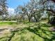 Large grassy backyard with mature shade trees and storage trailer at 6207 Ridge Top Dr, New Port Richey, FL 34655