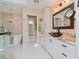 Spa-like bathroom with a double vanity, stone countertops, a soaking tub, and modern fixtures at 6207 Ridge Top Dr, New Port Richey, FL 34655