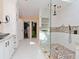 Luxury bathroom with a glass-enclosed shower, double vanity, and access to a walk-in closet at 6207 Ridge Top Dr, New Port Richey, FL 34655