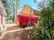 Red trailer parked in driveway with cover, greenery, and mature tree at 6207 Ridge Top Dr, New Port Richey, FL 34655