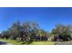 Well-maintained home with mature trees and lush lawn on a clear day at 6207 Ridge Top Dr, New Port Richey, FL 34655