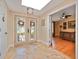 Elegant foyer with double glass doors, stone flooring, and a decorative chandelier, creating a grand entrance at 6207 Ridge Top Dr, New Port Richey, FL 34655