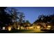 Charming home with mature trees and manicured lawn, illuminated at night at 6207 Ridge Top Dr, New Port Richey, FL 34655