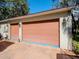This two-car garage features a neutral paint job, vintage lantern sconces, and a double wide driveway at 6207 Ridge Top Dr, New Port Richey, FL 34655