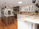Gourmet kitchen with granite countertops, a large island, stainless steel appliances, and ample cabinet space for storage at 6207 Ridge Top Dr, New Port Richey, FL 34655