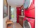 This laundry room includes a modern red washer and dryer set, cabinets, and a window at 6207 Ridge Top Dr, New Port Richey, FL 34655