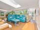 Bright living area featuring a blue sofa, light wood floors and sliding doors leading to the outside at 6207 Ridge Top Dr, New Port Richey, FL 34655