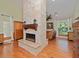 Cozy living room with a stone fireplace, hardwood floors, and large windows overlooking the backyard at 6207 Ridge Top Dr, New Port Richey, FL 34655