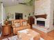 Inviting living room showcasing a stone fireplace, leather sofa, and hardwood floors at 6207 Ridge Top Dr, New Port Richey, FL 34655