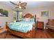 Tropical-themed main bedroom with a decorative bed, hardwood floors, and natural light at 6207 Ridge Top Dr, New Port Richey, FL 34655