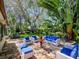 Outdoor stone patio with white wicker furniture, blue cushions, and a pineapple fountain at 6207 Ridge Top Dr, New Port Richey, FL 34655