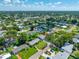 An aerial view shows the property within a neighborhood with mature trees, green lawns, and blue skies at 6219 Hampton N Dr, St Petersburg, FL 33710