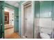 This bathroom has a white tiled shower, toilet, shelving, and access to other rooms in the home at 6219 Hampton N Dr, St Petersburg, FL 33710
