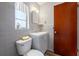 Bathroom with gray tile, sink, and toilet with wood-look floor at 6219 Hampton N Dr, St Petersburg, FL 33710