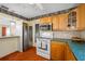 Traditional kitchen with wood cabinets, green countertops, and modern stainless-steel appliances at 6219 Hampton N Dr, St Petersburg, FL 33710