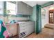 This laundry room has cabinets, a sink, a door to the outside, and access to additional rooms at 6219 Hampton N Dr, St Petersburg, FL 33710