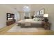Staged bedroom featuring a large bed, TV, wood floors, and natural light at 6301 13Th N Ave, St Petersburg, FL 33710