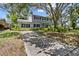 Charming two-story home featuring a manicured front lawn with mature trees for ample shade at 6301 13Th N Ave, St Petersburg, FL 33710