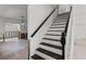 Classic staircase featuring dark wood treads, white risers, and a sleek black handrail for a modern touch at 6301 13Th N Ave, St Petersburg, FL 33710