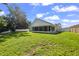Spacious backyard featuring a well-maintained lawn, screened-in porch, and white fence at 6318 Ashfield Pl, Wesley Chapel, FL 33545