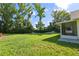 Large backyard with lush green grass and mature trees providing shade at 6318 Ashfield Pl, Wesley Chapel, FL 33545