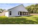 Exterior view of home showcasing a well-maintained backyard and covered patio at 6318 Ashfield Pl, Wesley Chapel, FL 33545