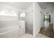 Bathroom featuring a soaking tub, glass shower and an arched window for natural light at 6318 Ashfield Pl, Wesley Chapel, FL 33545