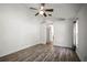 Spacious bedroom featuring wood-look flooring, a ceiling fan, and an ensuite bathroom at 6318 Ashfield Pl, Wesley Chapel, FL 33545