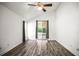 Bright bedroom with hardwood floors, a ceiling fan, and sliding glass doors to the outside at 6318 Ashfield Pl, Wesley Chapel, FL 33545