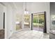 Bright breakfast nook featuring tile flooring, large windows, and sliding glass doors leading to outdoor patio at 6318 Ashfield Pl, Wesley Chapel, FL 33545
