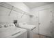 A laundry room featuring a washing machine, dryer, wire shelving and tiled floors at 6318 Ashfield Pl, Wesley Chapel, FL 33545