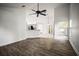 Open living room with wood flooring, a ceiling fan, and view to the kitchen at 6318 Ashfield Pl, Wesley Chapel, FL 33545