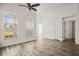 Spacious, bright living room with wood floors, arched windows, and a ceiling fan at 6318 Ashfield Pl, Wesley Chapel, FL 33545