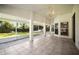 Large screened patio with tile flooring, ceiling fan, and views of the landscaped backyard at 6318 Ashfield Pl, Wesley Chapel, FL 33545