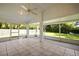 Spacious covered patio with tile flooring, ceiling fan, and views of the lush backyard at 6318 Ashfield Pl, Wesley Chapel, FL 33545