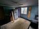 Outdated kitchen with a vintage refrigerator, cabinets, and a ceiling fan and adjacent window with plenty of sunlight at 6515 30Th N St, St Petersburg, FL 33702