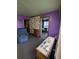 Living room area exhibiting purple paint, floral wallpaper, a recliner, and a doorway to another room at 6515 30Th N St, St Petersburg, FL 33702