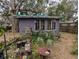 Exterior view of weathered shed with adjacent greenery, featuring multiple windows and a dark gray exterior at 6515 30Th N St, St Petersburg, FL 33702