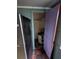 Small storage room with a hot water heater, old flooring, and a purple door next to a black refrigerator at 6515 30Th N St, St Petersburg, FL 33702